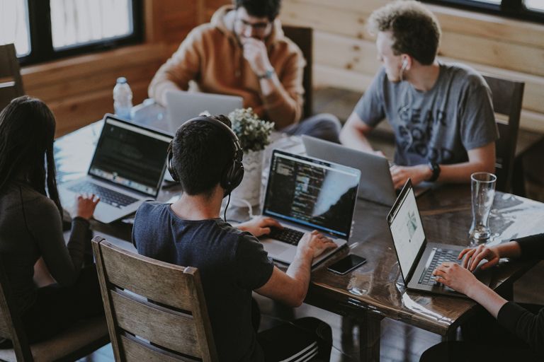 team of employees sat together with laptops