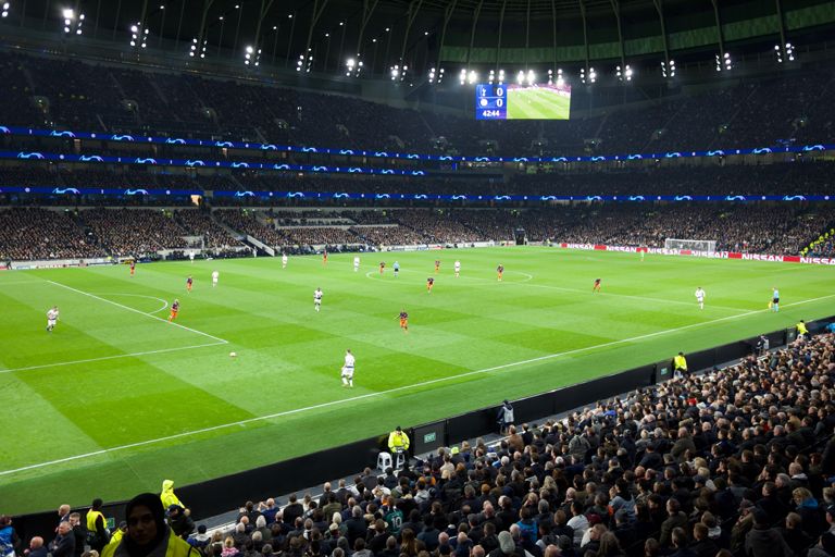 Football match being played in floodlit stadium