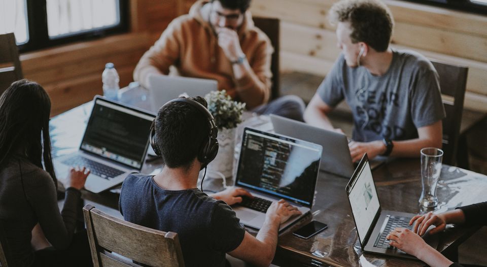 team of employees sat together with laptops 