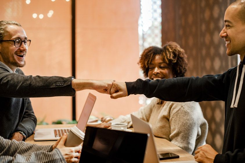 People in a meeting, fistbumping over the table