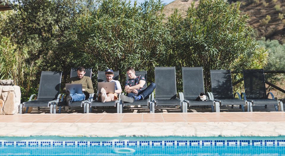 George, Sam and Henry on laptops beside pool