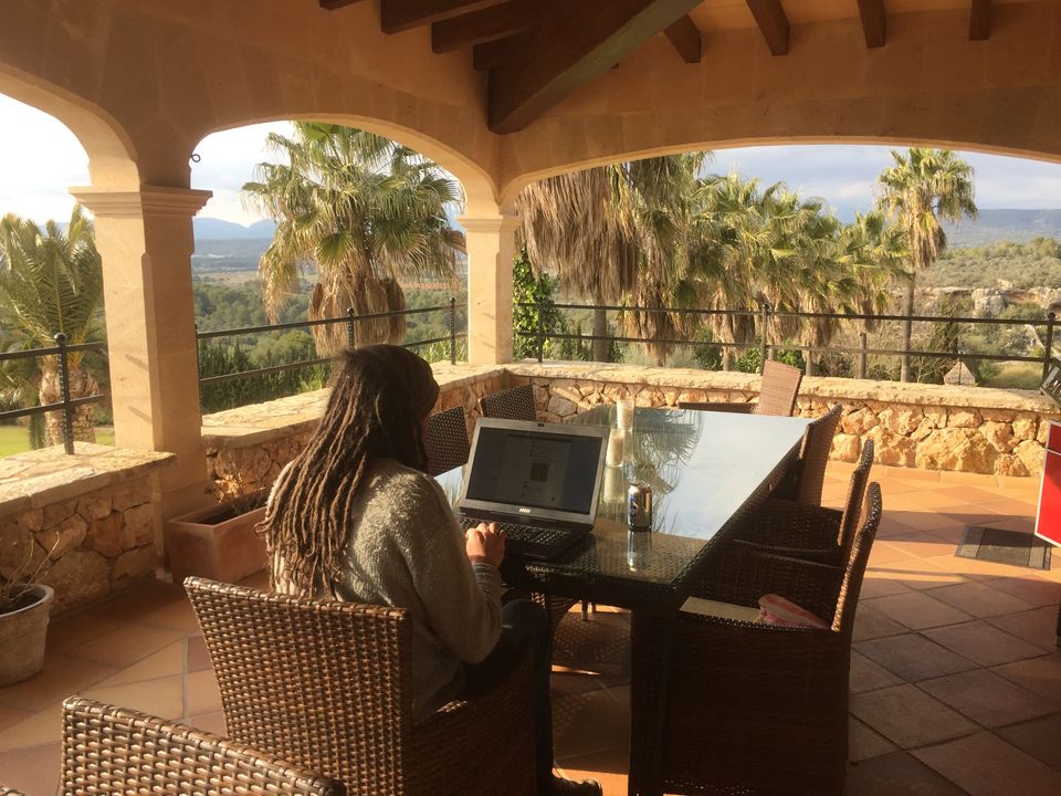 Simon working with laptop on balcony