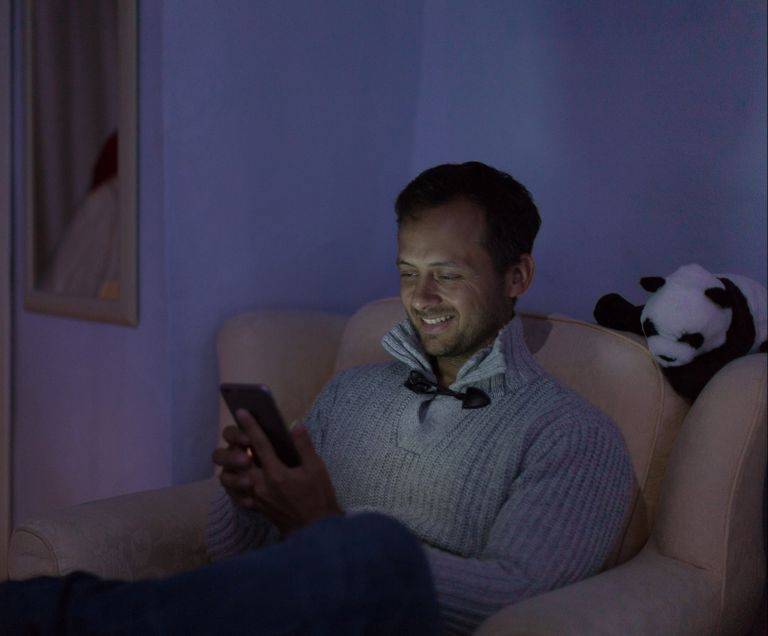 Man sat in dark using Power Cut Reporter app